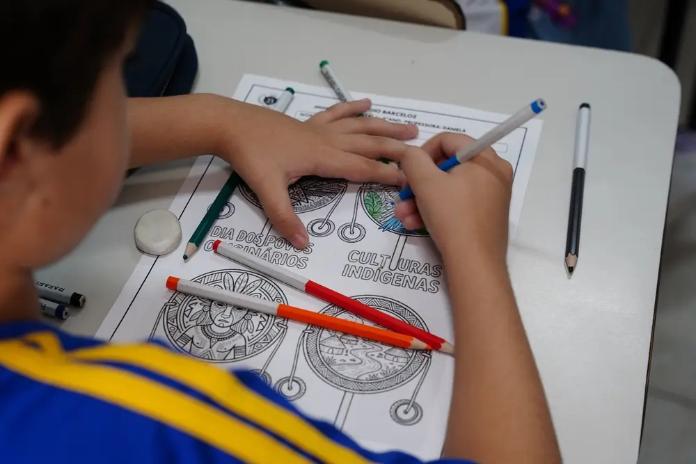 Aluno do Colégio Barcelos realizando atividade pedagógica sobre culturas indígenas
