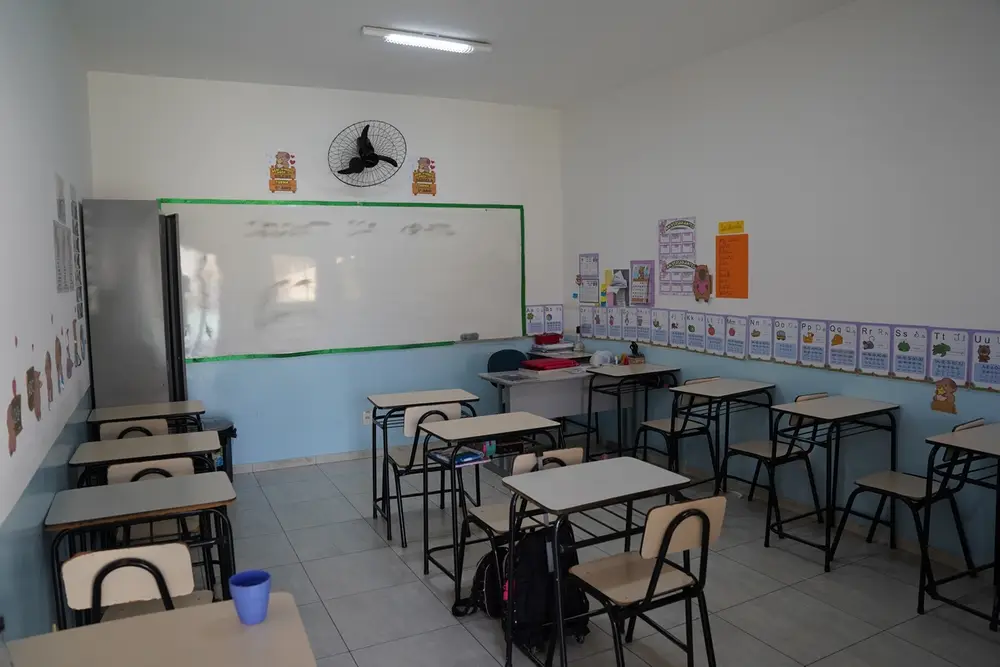 Sala de aula organizada com carteiras e lousa no Colégio Barcelos